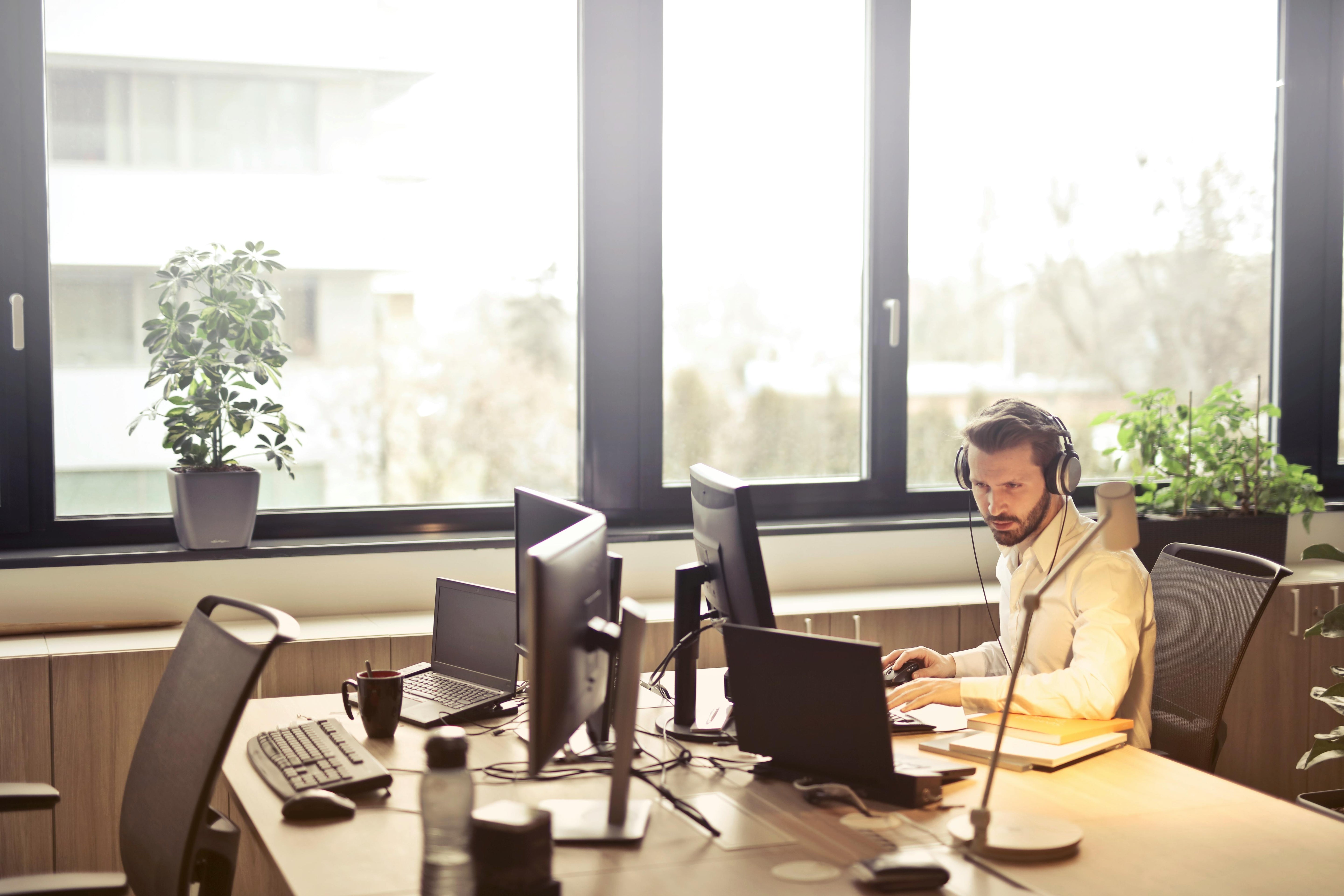 Medewerker met hoofdtelefoon aan een computer