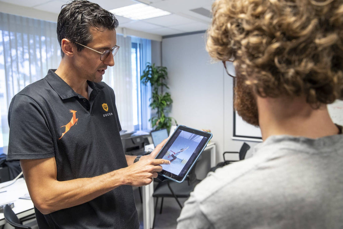 Coach geeft uitleg aan een deelnemer tijdens de Vitacheck