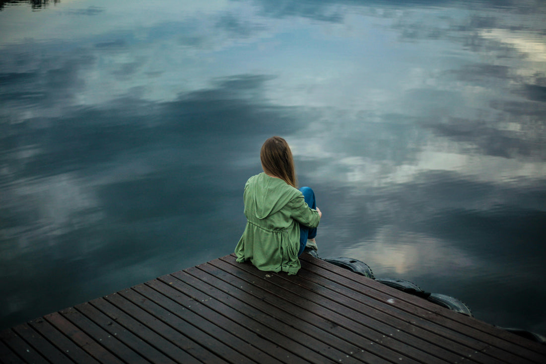 Dame die over een meer staart, als symbool voor burnout