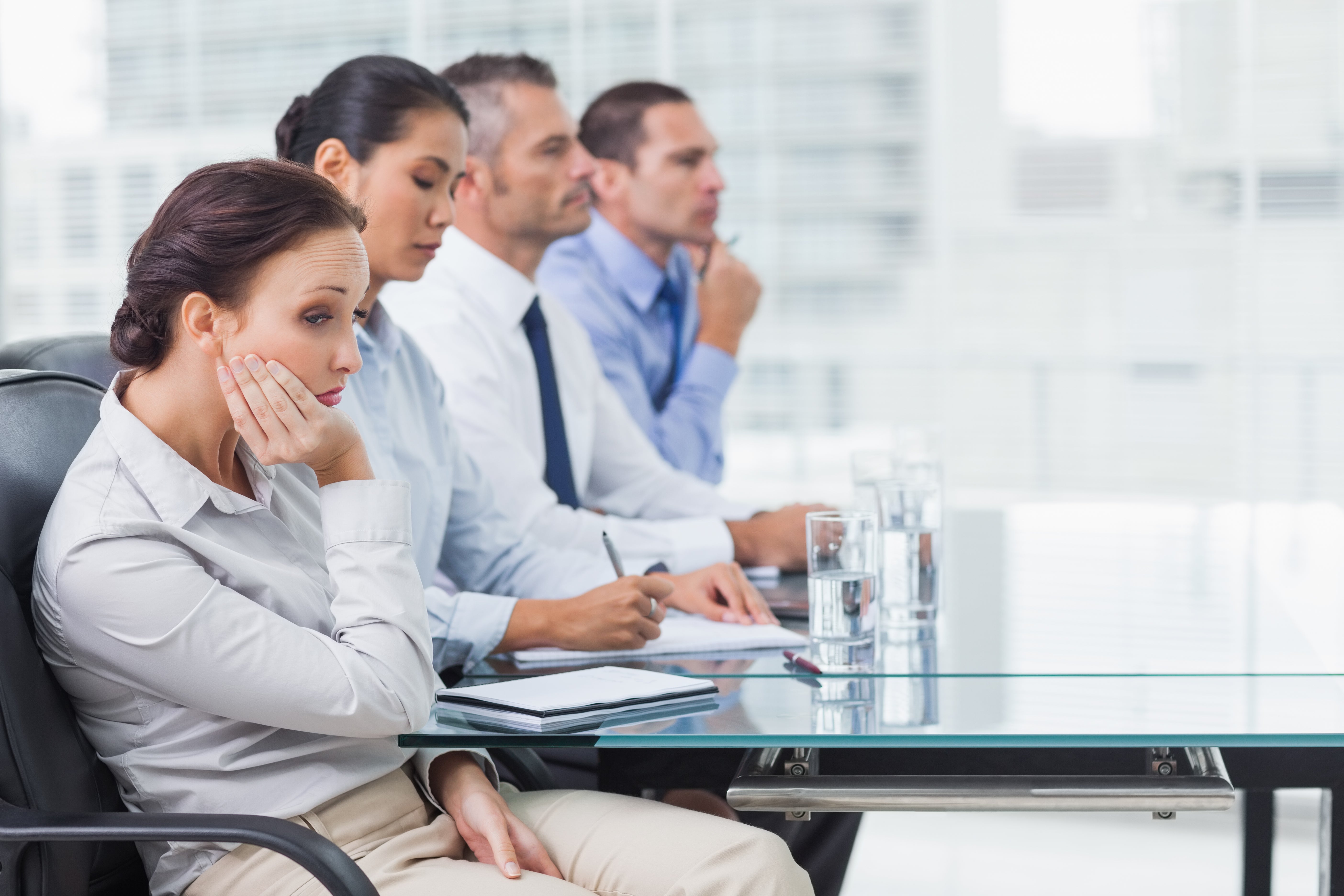 Onderuitgezakte medewerkers tijdens een vergadering